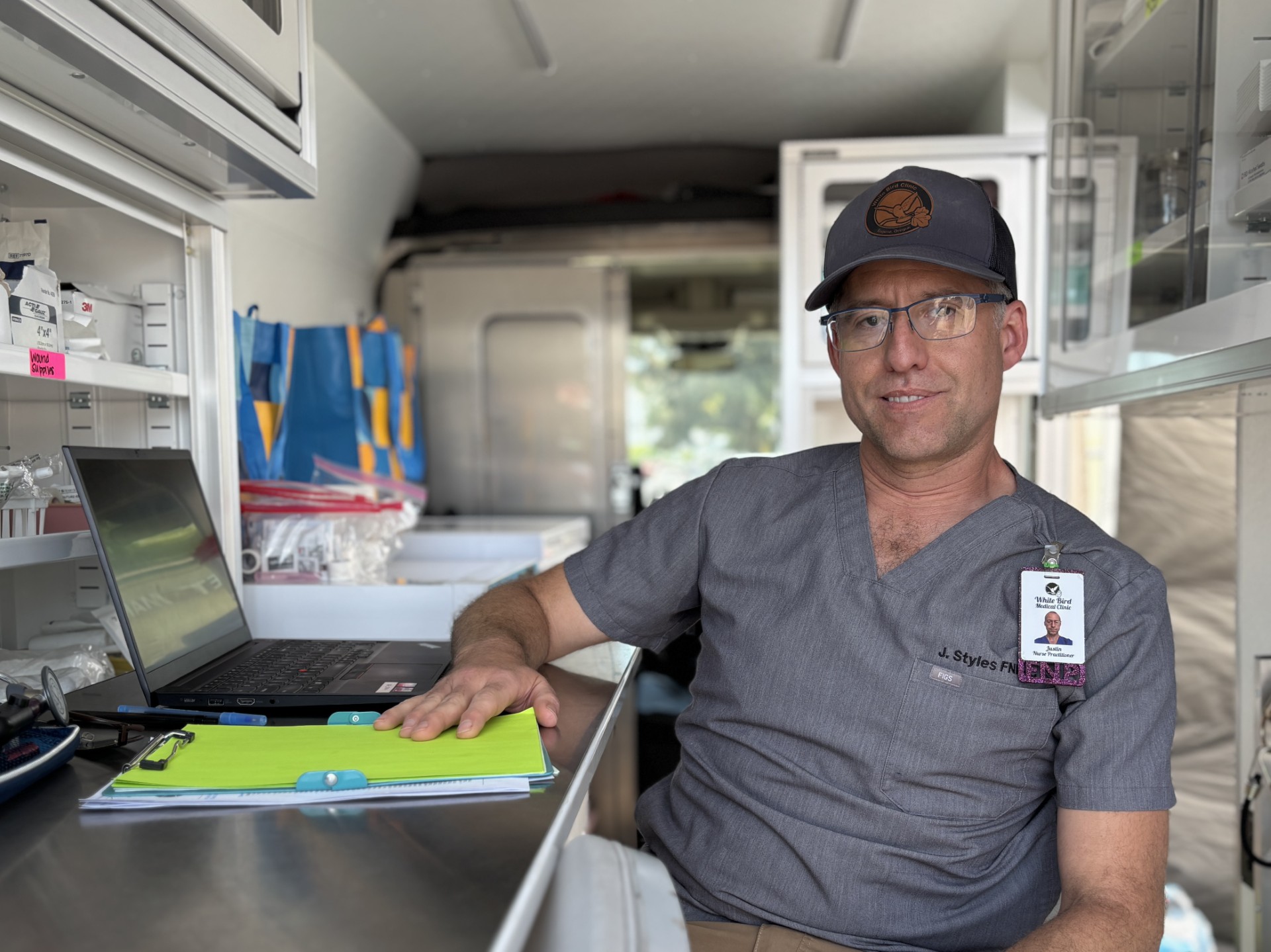 Inside_Mobile_Clinic_Van_Justin A male mobile medical clinic staff member sitting at a desk inside the van.